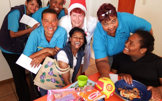 Marie Reid (met â€˜n Kersvaderhoedjie op) saam met  Gansbaai Elim Huis se personeel en twee inwoners 